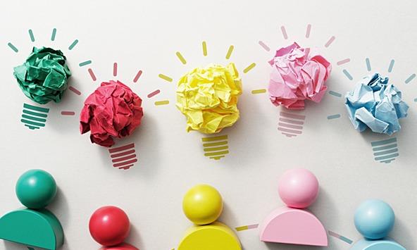 colourful figures with colourful bits of paper rolled into balls symbolising creative ideas and teamwork